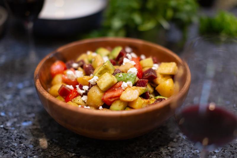 Fresh Moroccan salad with beets, avocado and feta in a wooden bowl